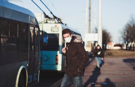 New type COVID-19 coronavirus pneumonia. People wearing surgical mask standing at the bus stop of public transportの写真素材