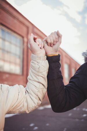 Elbow bump. New novel greeting to avoid the spread of coronavirus. Couple friends meet in street and instead of greeting with a hug or handshakeの写真素材