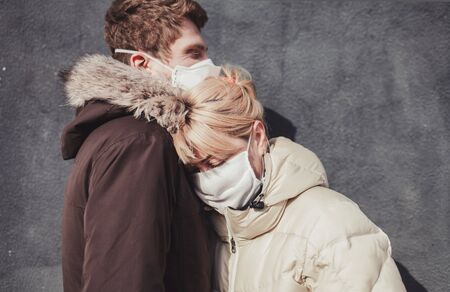 Couple protective medical mask near wall in street. Environmental pollution concept.の写真素材