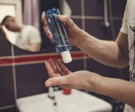 Hands squeezing soap out to wash hands with soap to prevent the spread of germs and bacteriaの写真素材