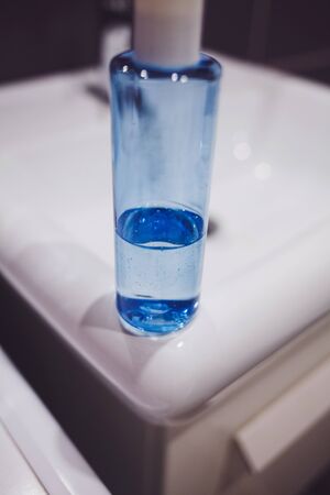 blue bottle of liquid soap on the sinkの写真素材