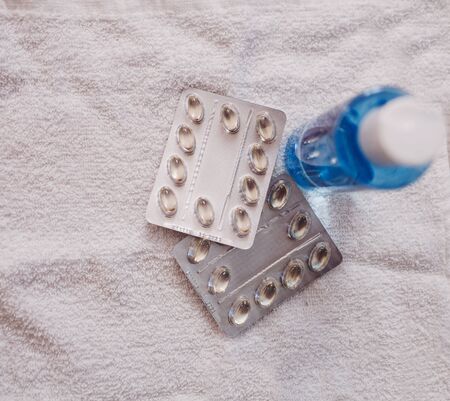 virus tablets in capsules and a bottle of antibacterial soapの写真素材