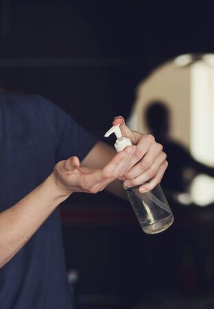 close-up mens hands using wash hand sanitizer gel pump dispenser.の写真素材