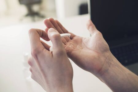 man puts a protective antibacterial gel on his hands. concept of health and cleanlinessの写真素材