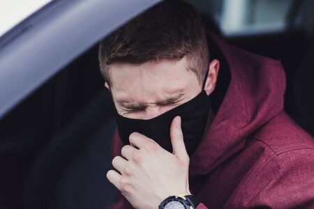 man the driver in the mask coughs. violated the quarantine. pandemic coronavirusの写真素材