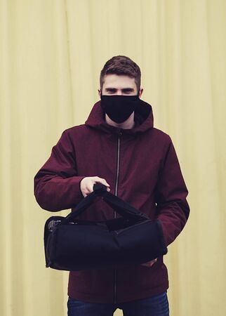 Delivery man holding bag with food outdoors food delivery man in protective maskの写真素材