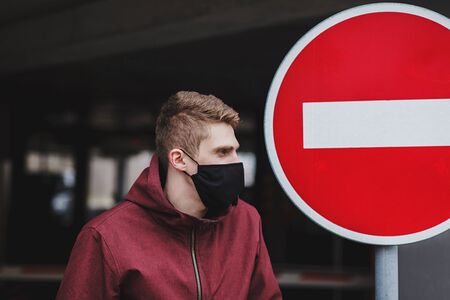 man in the street wearing black mask. coronavirus pandemic and quarantine in the cityの写真素材