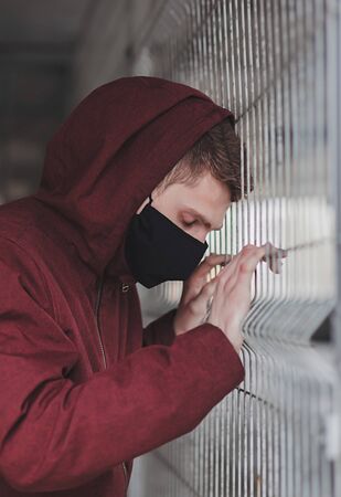 man in a protective black mask on the street. Poor health during the coronavirus pandemicの写真素材