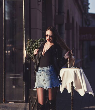 Beautiful young woman is wearing leather jacket and skirt. Urban portraitの写真素材