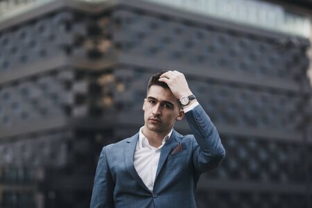 young businessman in suit standing in city. Man wearing watchの写真素材
