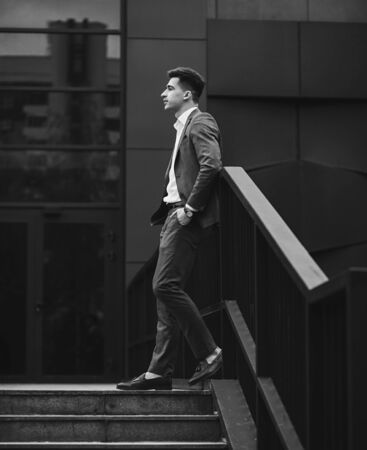 Portrait of a trendy man in full suit and loafers. Looking awayの写真素材