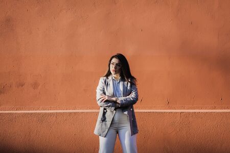 Photo of stylish young woman posing over wall backgroundの写真素材