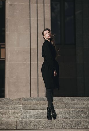 Beautiful sexy young girl with long hair wearing high heels. Walk on the street in casual stylの写真素材