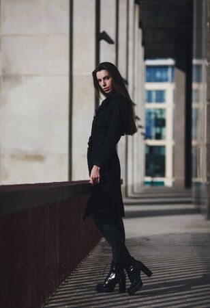 portrait of pretty girl with long hair in city. She wears black coat.の写真素材
