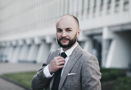 Handsome and successful man in an expensive suit. He is in a white shirt with a tie.