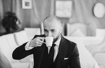 Business person drinking coffee. Young intelligent man or entrepreneur relaxing in outdoors cafeの写真素材