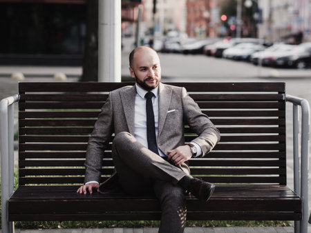 Successful bearded businessman in suit with bicycle in city