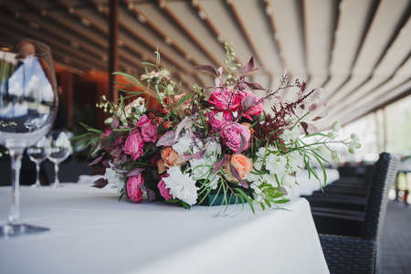 Beautiful bouquet of wedding flowers on the restaurant tableの写真素材