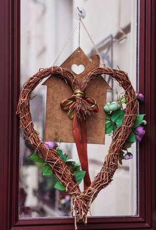 Stylish christmas wreath with red heart, modern decor on store front or building facadeの写真素材