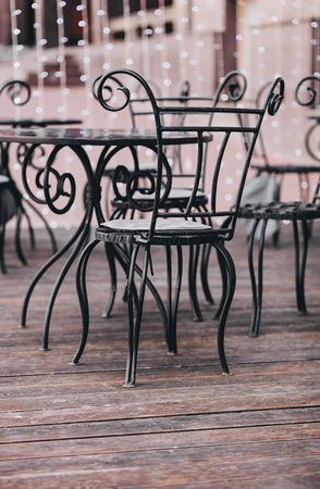 Street cafe, empty tables outdoor, elegant setting for celebration. Vintage wooden chairs