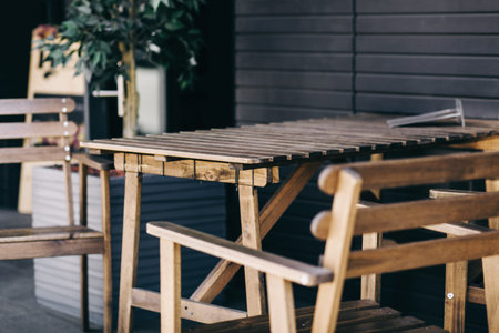 Street cafe, empty tables outdoor, elegant setting for celebration. Vintage wooden chairs