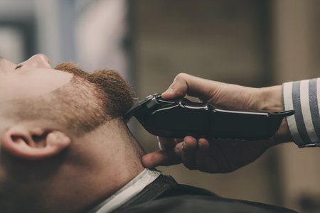 Brutal bearded man gets a shave in the salon.の写真素材