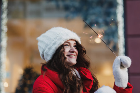 Beautiful woman winter portrait. Smiling girl wearing warm red coat and warm mittensの写真素材