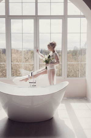 Bride.Young fashion model with hairstyle and make up holding flowersの写真素材