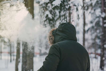 Stylish young man smoking electronic cigarette outdoor. Man vaping.の写真素材