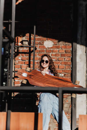 stylish smiling girl in sunglasses with a longboard on a summer weekendの写真素材