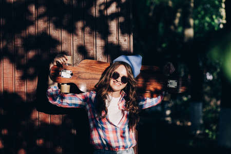 Hipster woman with a skateboard in the sunny day. Freedom and independence youth conceptの写真素材