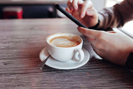 sugar cubes with tongs on a wooden background. cappuccino cup in the cafeの写真素材