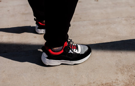 Portrait of handsome stylish urban man wearing black black hoodie and sneakers. Copy space. Advertising concept.の写真素材