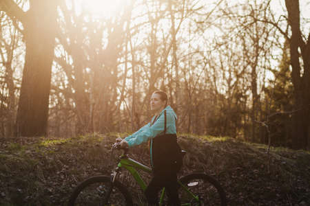 Young woman traveling with bicycle in park. healthy active lifestyle travelerの写真素材