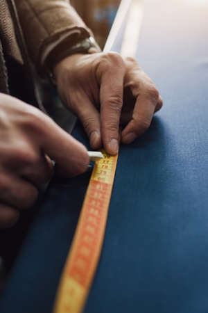 the tailor marks the lines on the clothes with chalk. private tailoring businessの写真素材