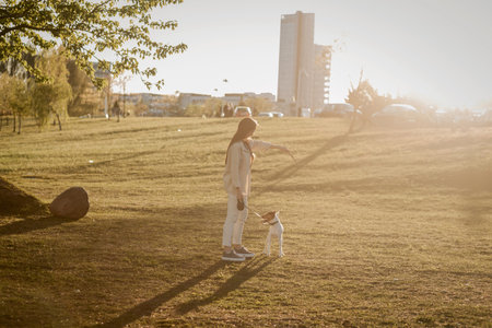 Young beautiful woman relaxing with dog in park. summer style concept