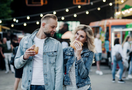 Cheerful couple eating outdoors, having fun.