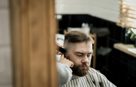 barber cuts the customer's hair with an electric razor. the concept of beautyの写真素材