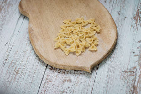 organic food. raw pasta, eggs and flour on a wooden boardの写真素材