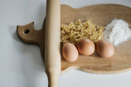 organic food. raw pasta, eggs and flour on a wooden boardの写真素材
