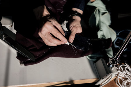 Designer using chalk to mark a pattern on fabric. tailor's hands in the atelierの写真素材