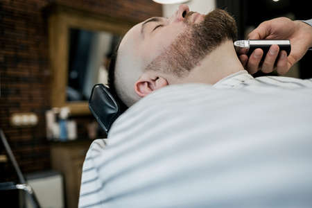 male client getting haircut at barber shop from professional hairstylist.の写真素材