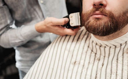 male client getting haircut at barber shop from professional hairstylist.の写真素材