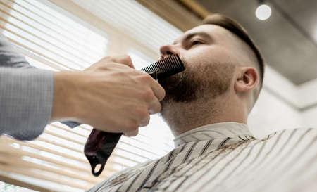 male client getting haircut at barber shop from professional hairstylist.の写真素材
