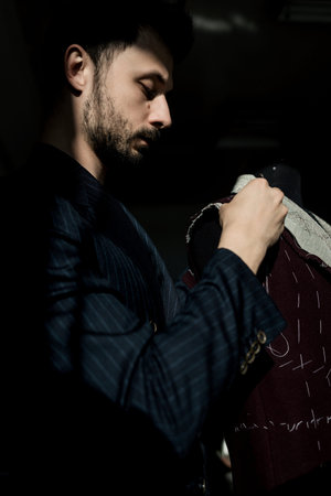 male tailor is working on tailoring a suit. workshop