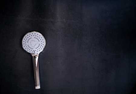 stainless steel shower head with the turn lever of a spray settings on a dark background. copy spaceの写真素材