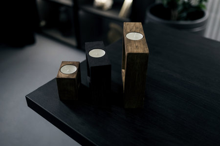 candles on a wooden stand in a dark interior. decor for the apartmentの写真素材