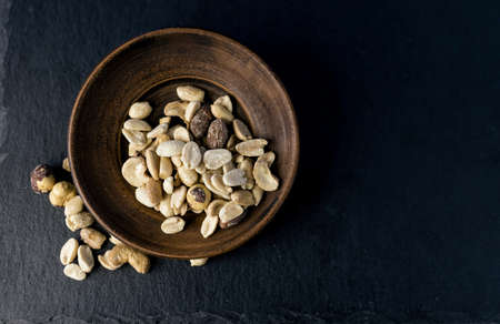 variety of nuts on a vintage bowl. healthy food or snack on a black background. dietの写真素材