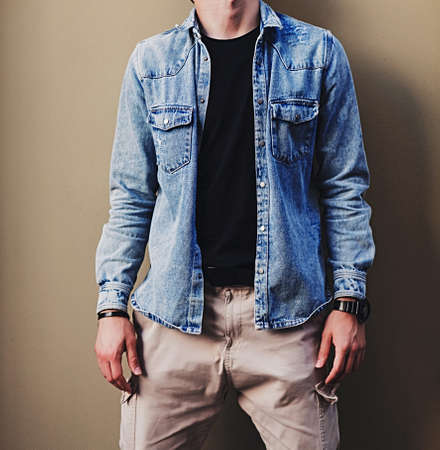 trendy man in denim jacket near wall. casual styleの写真素材