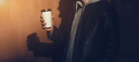 drinks, technology and people concept - man with coffee cup near red wall backgroundの写真素材